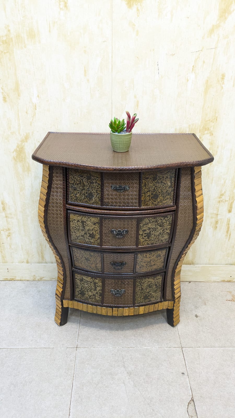 IMPORTED Antique Anglo-Indian rattan and pressed brass bombe bedside chest with four drawers.