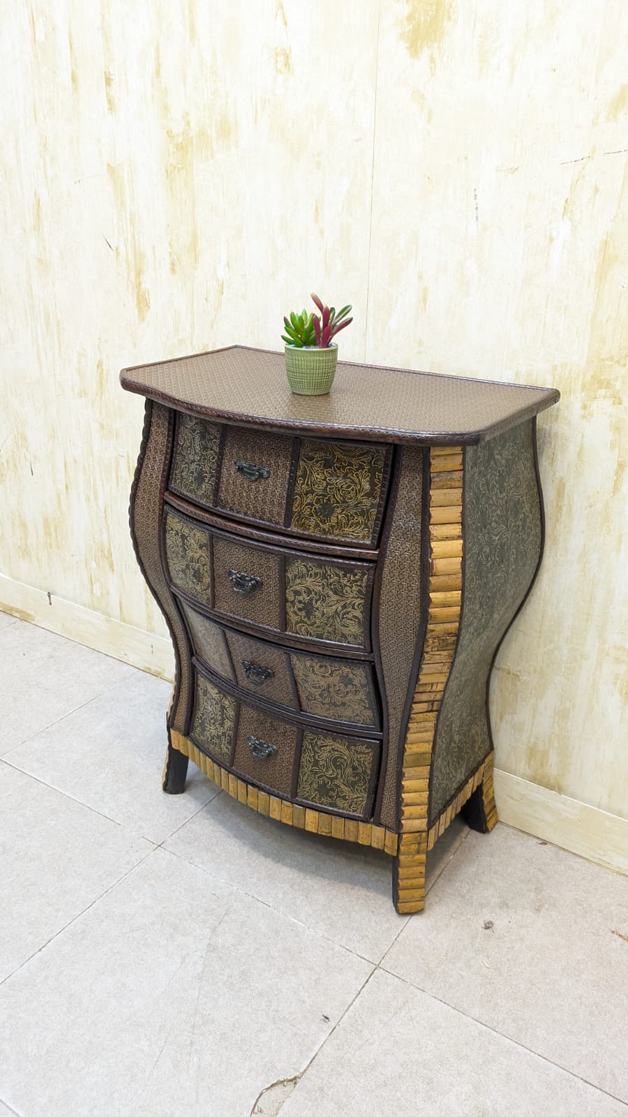 IMPORTED Antique Anglo-Indian rattan and pressed brass bombe bedside chest with four drawers.