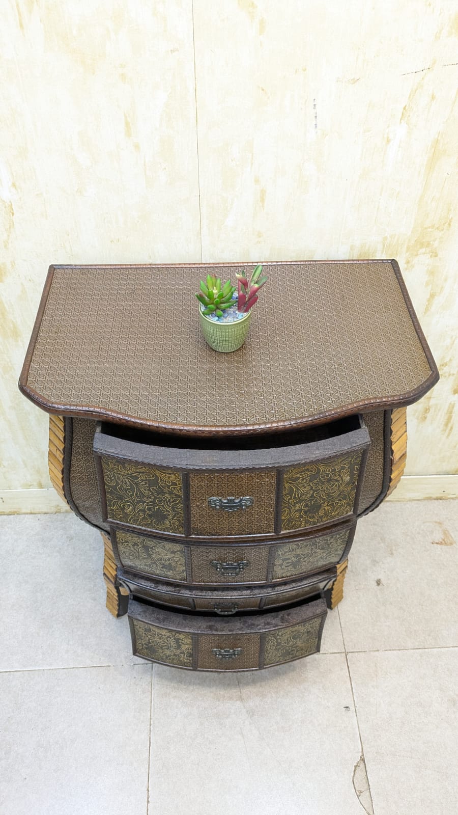 IMPORTED Antique Anglo-Indian rattan and pressed brass bombe bedside chest with four drawers.