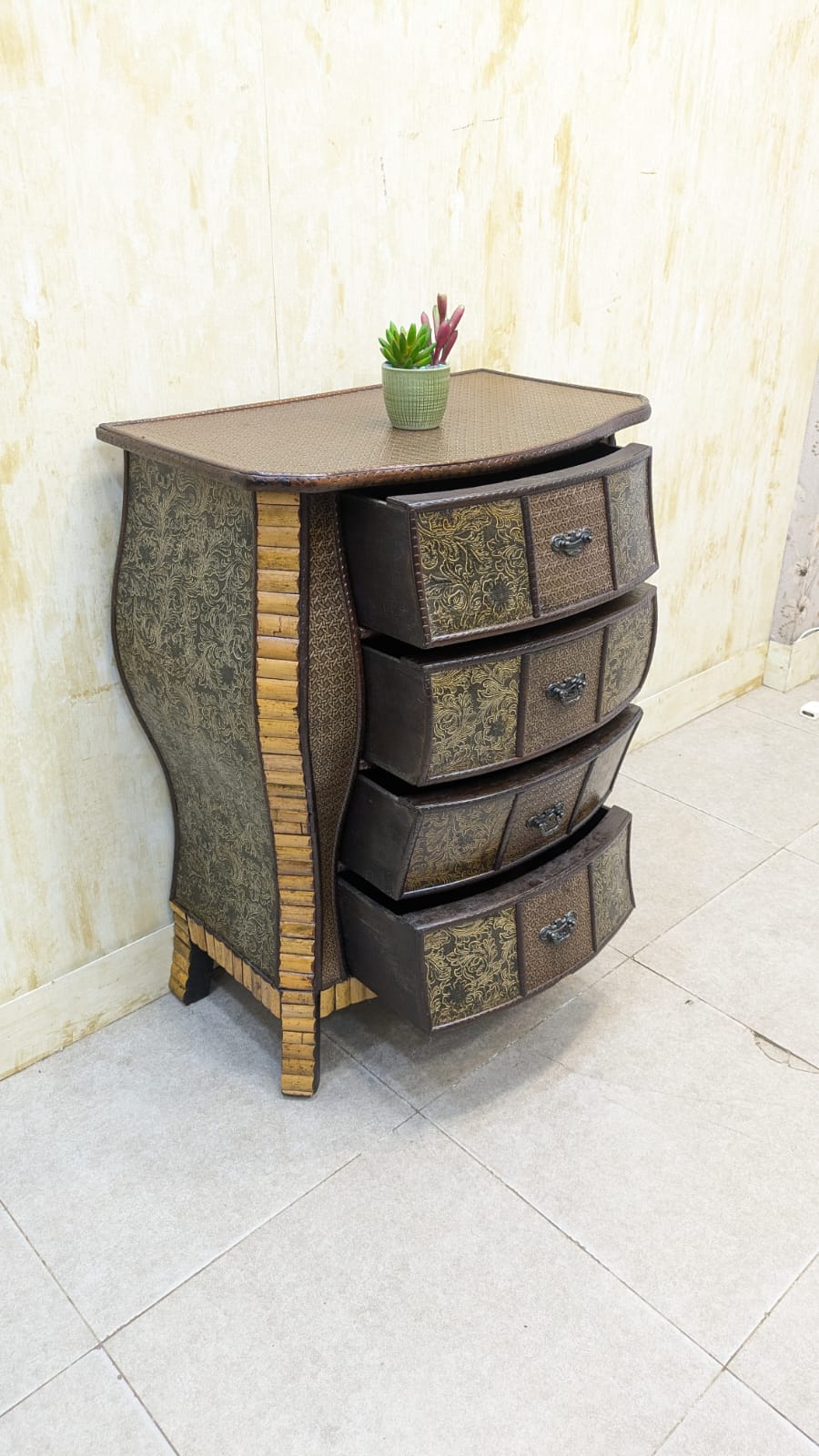 IMPORTED Antique Anglo-Indian rattan and pressed brass bombe bedside chest with four drawers.