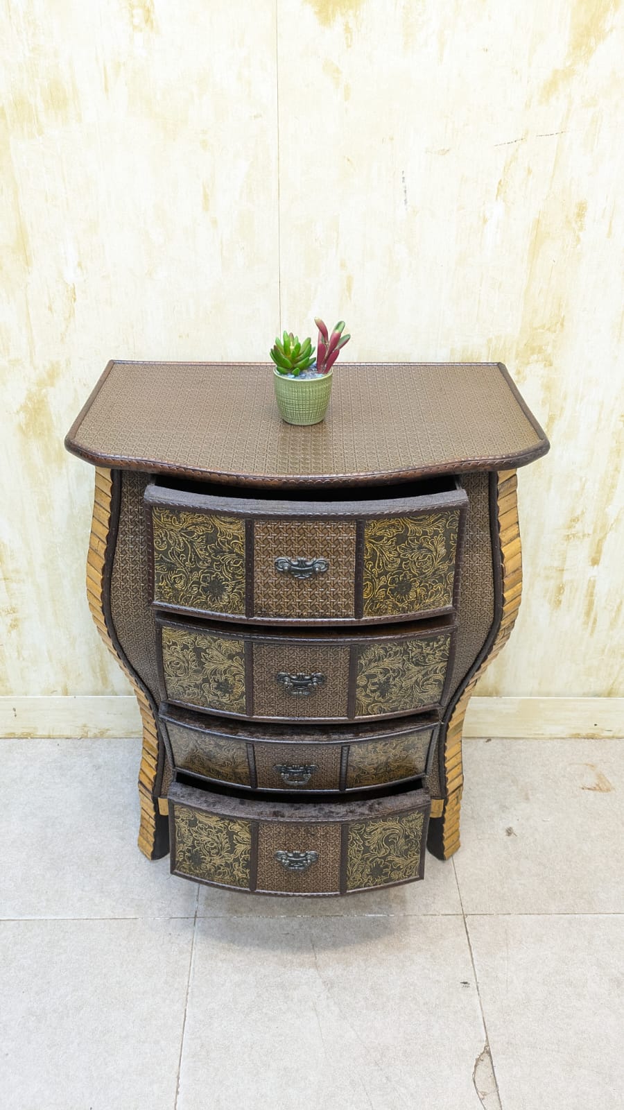 IMPORTED Antique Anglo-Indian rattan and pressed brass bombe bedside chest with four drawers.